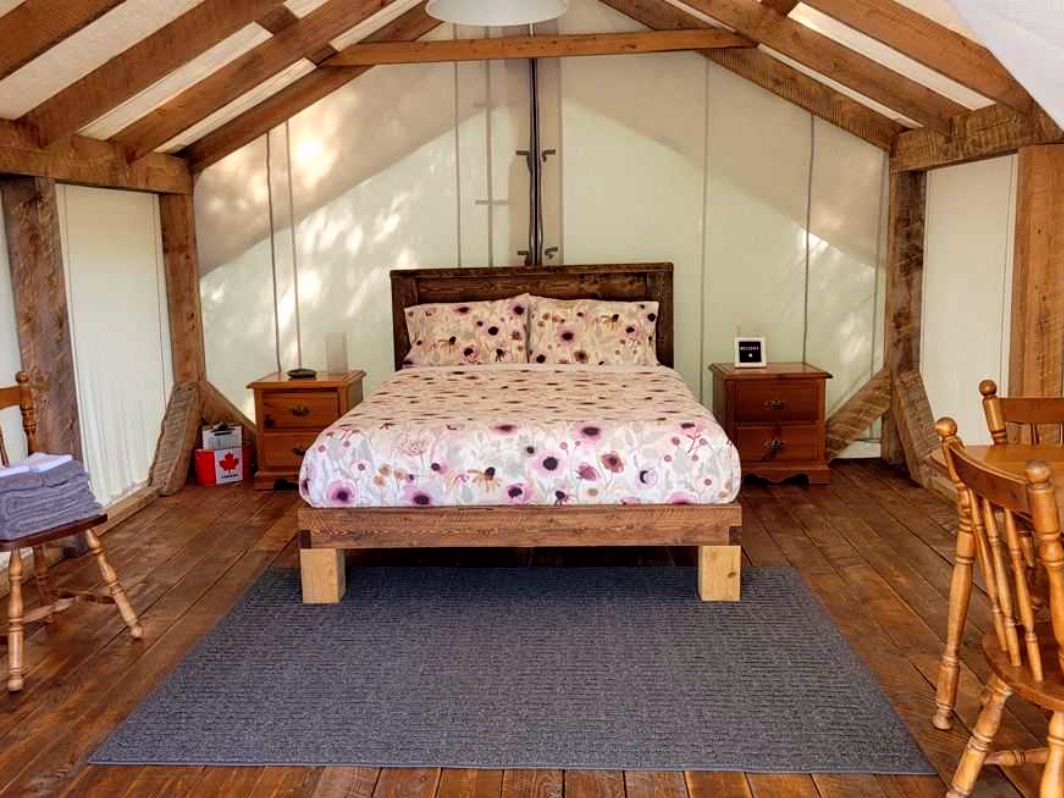 Interior of Pine Tent with queen bed at Nova Scotia glamping retreat